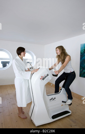 Young woman working out on a stationary bicycle Stock Photo