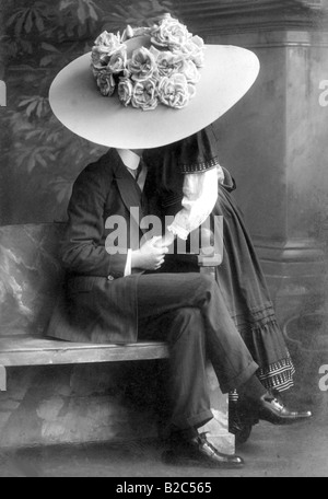 Young pair kissing under a giant hat, historical photo, circa 1910 Stock Photo