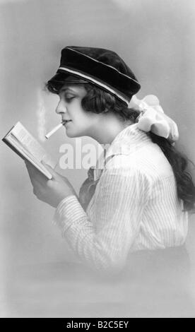 Modern youth, woman smoking cigarette and reading, historic picture from about 1910 Stock Photo