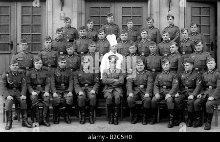 Cook posing in-between a group of soldiers, historic picture from about 1940 Stock Photo