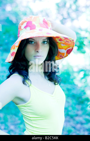 cute dark-haired woman in yellow shirt with a multicoloured hat Stock Photo