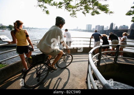 A jogger bicyclist and pedestrians are seen on a walkway on the banks of the Charles River in Boston Stock Photo
