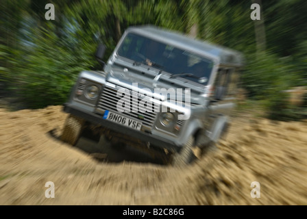 Off roading silver metallic Land Rover Defender 110 TD5 by Land Rover Experience used for driver training. Europe, UK, England. Stock Photo