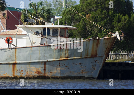 Large rusty old fishing boat chain looped around a concrete mooring on a  wet harbour (harbor) wall Stock Photo - Alamy