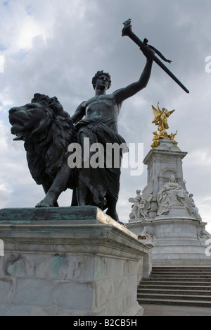 Bronze statue of a man and a lion, Queen Victoria Monument, in front of Buckingham Palace, London, England, Great Britain, Europ Stock Photo