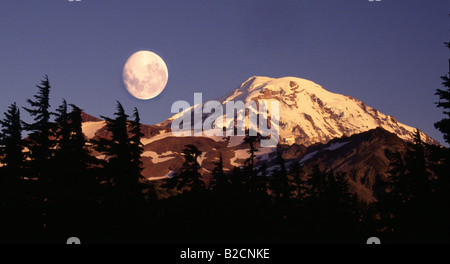 Mount Rainier from Spray Park with a full moon rising at sunset near Mowich Lake Washington Mt Rainier National park Stock Photo