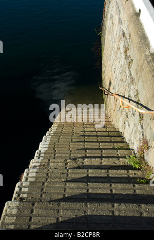 Harbour steps leading down to dark clear water Stock Photo