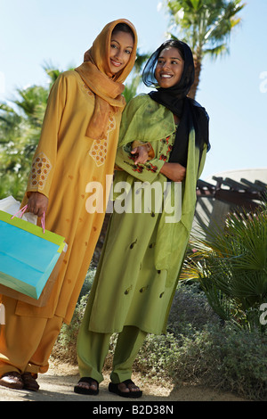 Two muslim women in traditional clothing, one with shopping bag Stock Photo