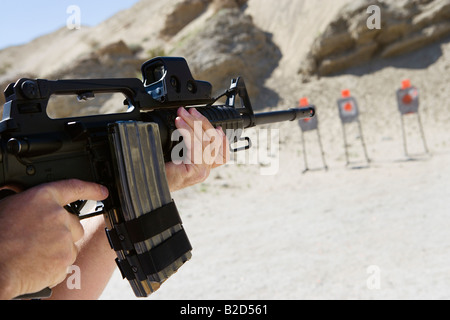 Man aiming machine gun at firing range, close up of hands Stock Photo