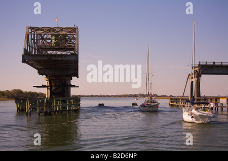 Boats pass under the Sullivan s Island South Carolina swing bridge along the Intercoastal Waterway near Charleston Stock Photo