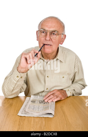 Vertical portrait of an elderly gentleman concentrating over the Sudoku puzzle in his daily newspaper Stock Photo