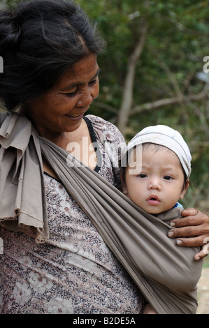 Vietnames Hill Tribe  woman looking at a baby boy she is carryin g in a sling Central Highlands Vietnam Stock Photo