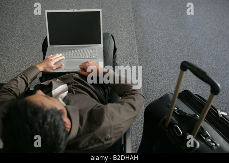 Young businessman using laptop in airport. Stock Photo