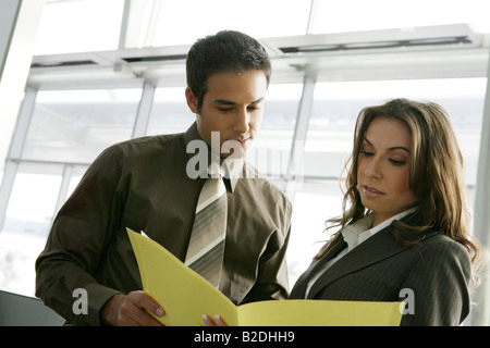 Businesspeople looking at paperwork in airport. Stock Photo