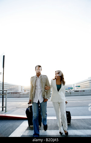 Young couple arriving at airport with luggage. Stock Photo
