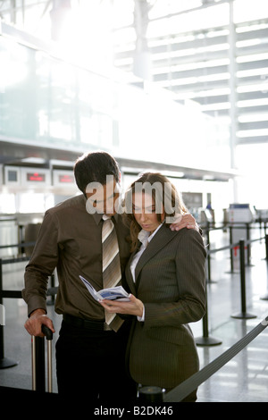 Businesspeople reading brochure at airport. Stock Photo