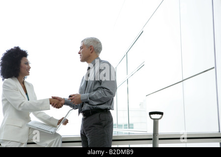 Businesspeople shaking hands at airport. Stock Photo