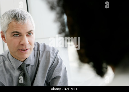 Mature businessman talking with colleage in airport. Stock Photo