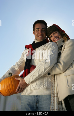 Portrait of young couple with pumpkin. Stock Photo