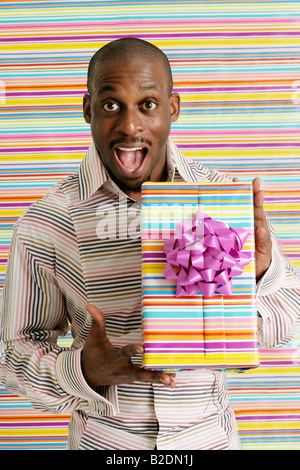 Excited African American man holding present. Stock Photo