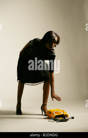 Young African American woman picking up purse. Stock Photo