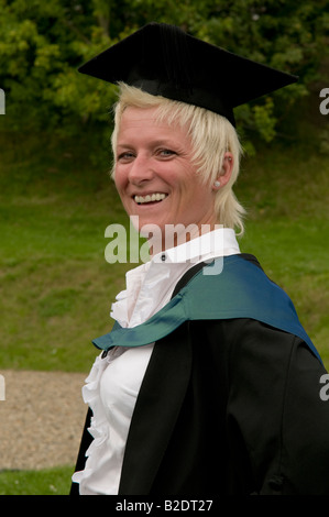 happy smiling Mature female student graduate wearing mortar board cap and gown Aberystwyth University graduation day Wales UK Stock Photo