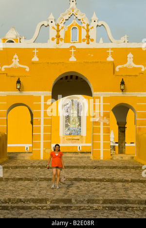 Girl in red at the entrance to the Convent of San Antonio de Padua in Izamal Yucatan Mexico Stock Photo