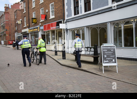 Ormskirk Lancashire England UK July A policeman pushing his bicycle with two Community Support Officers Stock Photo