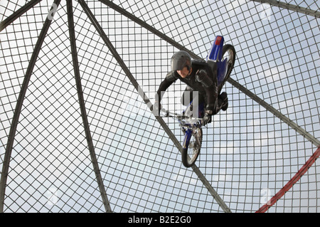 Extreme circus stunt riders show. Female motorcycle Globe of Death or Dome riders on lightweight motorcycles at Arbroath Seafront Spectacular, Angus, Stock Photo