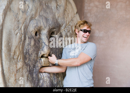 Man with hand in mouth and nose of Bocca della Verita Mouth of Truth Rome Lazio Italy Stock Photo