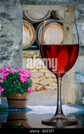 French wine tasting cellar Rose wine glass with rustic french winery arch and barrels in background France Stock Photo