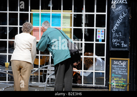 An elderly couple read a menu outside a restaurant in Stratford-upon-Avon. Picture by Jim Holden. Stock Photo