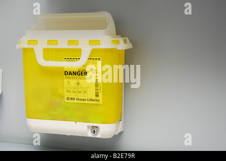 Sharps collector mounted on a wall for the disposal of syringes and other hazardous materials Stock Photo