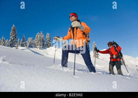 Two hikers walking on snowcovered landscape Vorarlberg Tyrol Austria Stock Photo