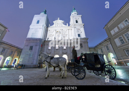 Side profile of coachman standing on horsedrawn carriage Stock Photo