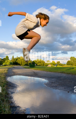 Side profile of girl jumping in mid air Stock Photo