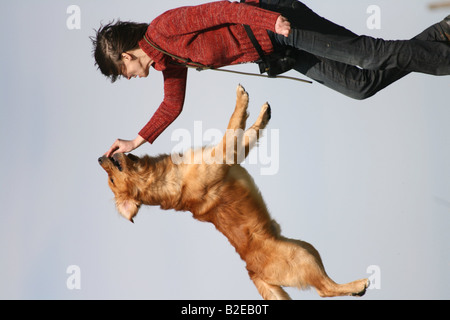 Woman playing with Golden Retriever in field Stock Photo