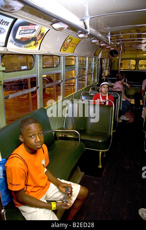 Black boy sitting in Rosa Parks city bus seat on display at The Henry Ford Museum in Dearborn Michigan Stock Photo
