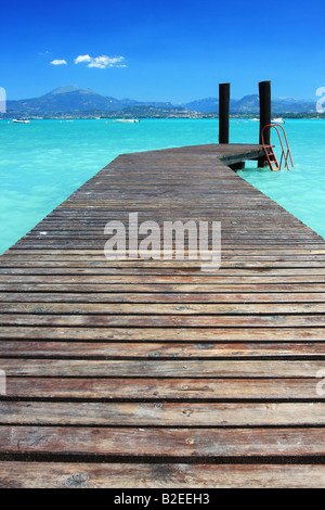 A small jetty on lake Garda Italy fantastic color in the sky and water Perfect for any sort of vacation concept Stock Photo