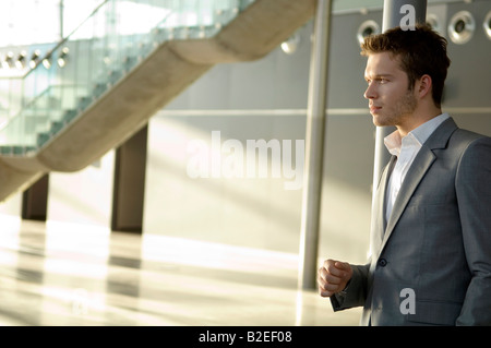 Businessman leaning against a pole Stock Photo