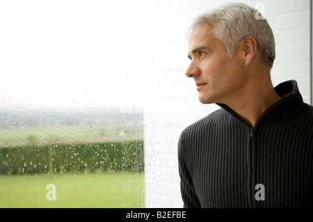 Close-up of a mature man looking out through a window Stock Photo
