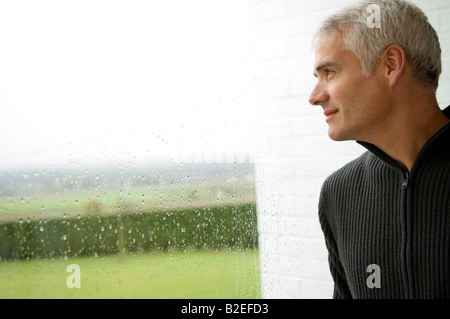 Close-up of a mature man looking out through a window Stock Photo