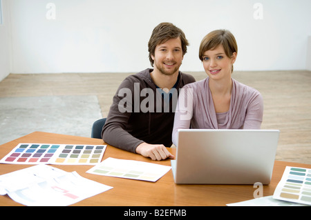 Portrait of a mid adult man and a young woman using a laptop Stock Photo