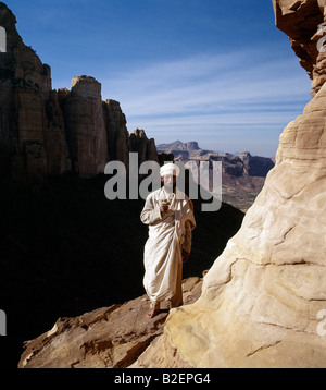 A priest stands outside the rock-hewn church of Abune Yemata in the Gheralta Mountains near Guh. Stock Photo