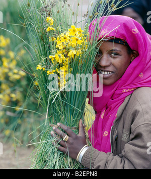 A woman sells yellow daisies by the side of the road in the outskirts of Addis Abeda, Ethiopia's capital city. Stock Photo