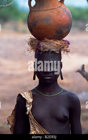 A young girl of the Mursi tribe. This girl is unmarried as she does not have the pierced lower lip and a clay lip plate. Stock Photo