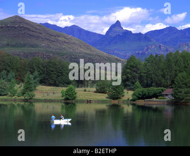 Two fisherman in a fishing boat on a lake in the Southern Drakensberg Stock Photo