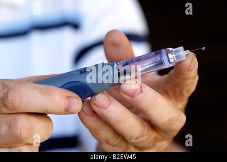 Insulin glargine injection soloution and needle in use by diabetic patient from a Opticlick company pen Stock Photo