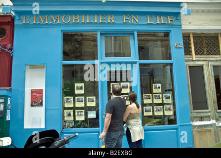 Paris France, Couple Window Shopping for Apartments Looking in Old French Shop Front of Real Estate Agent Window, property market, Vintage signs, Stock Photo