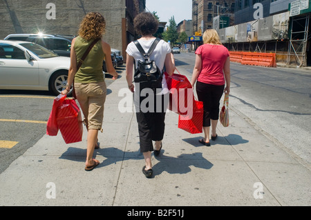 Shoppers walk down a street in Midtown in New York with their purchases from FAO Schwarz Stock Photo